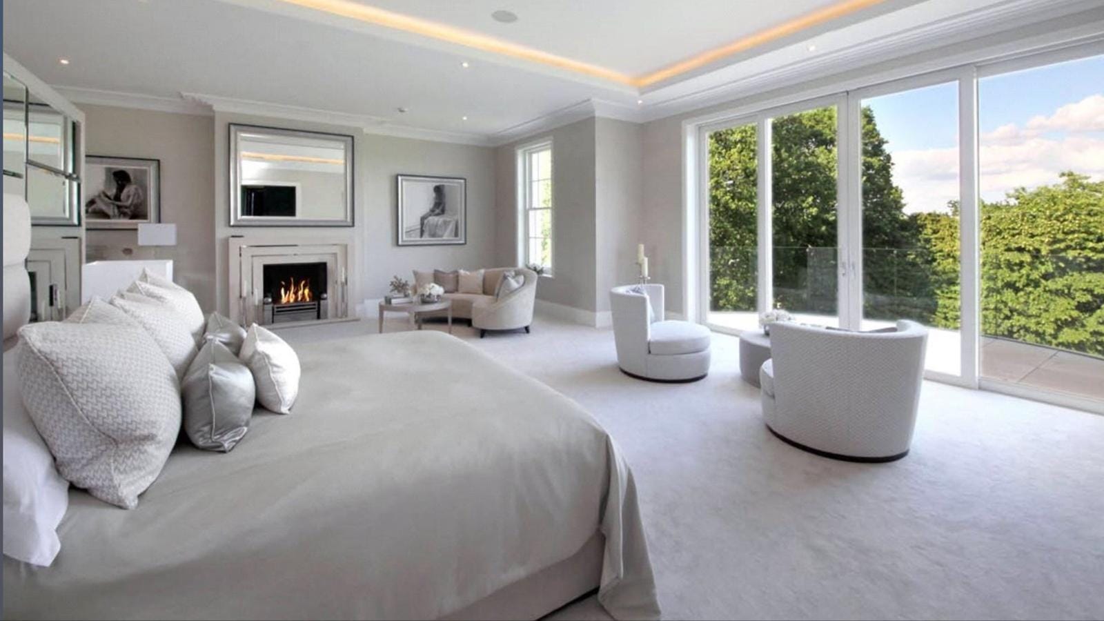 Large bedroom and sitting area with grey carpet and garden views