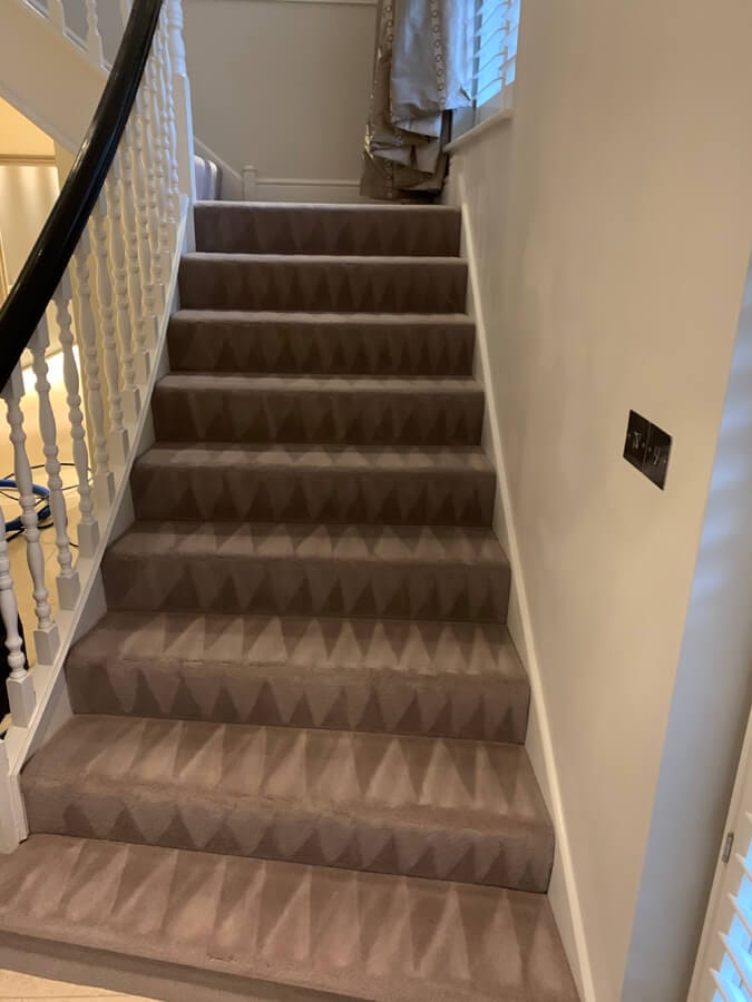 Stair Carpet Cleaning Surrey Full flight of stairs with a freshly cleaned brown carpet and white spindles